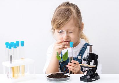 photo of a little girl playing with laboratory equipment