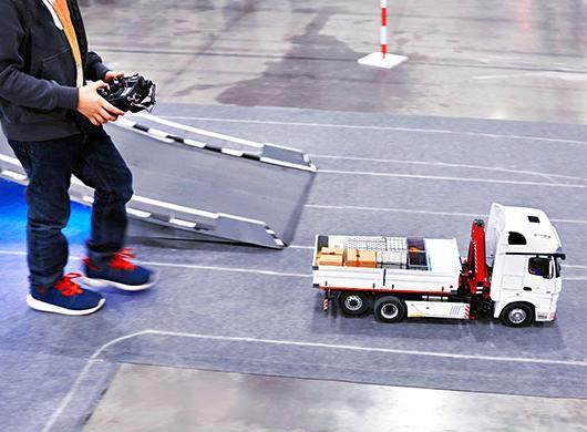 photo of boy playing with a remote-controlled truck